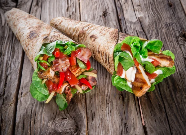 Chicken slices in a Tortilla Wrap on wood. — Stock Photo, Image
