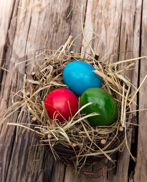 Easter colored eggs on hay — Stock Photo, Image