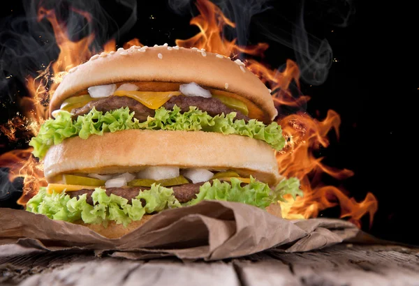 Pyszny hamburger z płomieni ognia — Zdjęcie stockowe