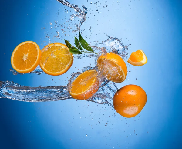 Апельсины с брызгами воды — стоковое фото