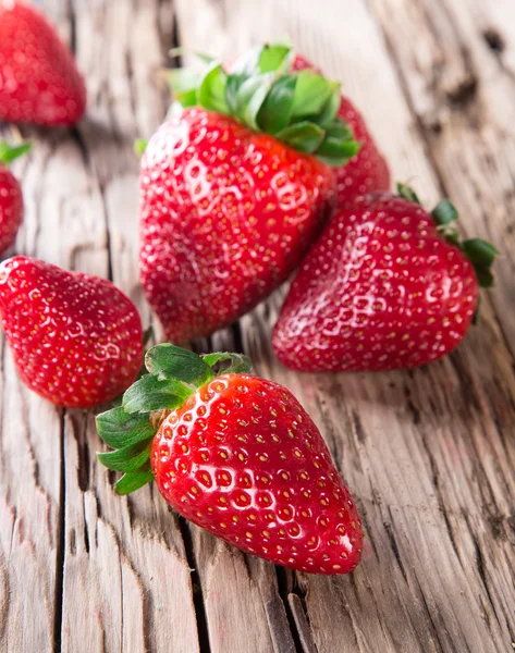 Erdbeere über hölzernen Hintergrund — Stockfoto