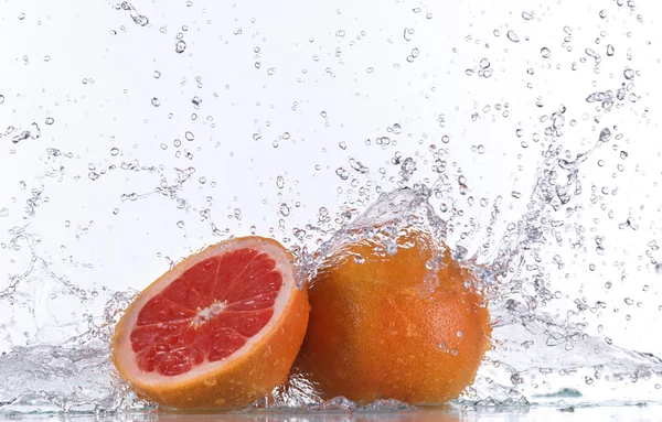 Grapefruity s stříkající vodě — Stock fotografie
