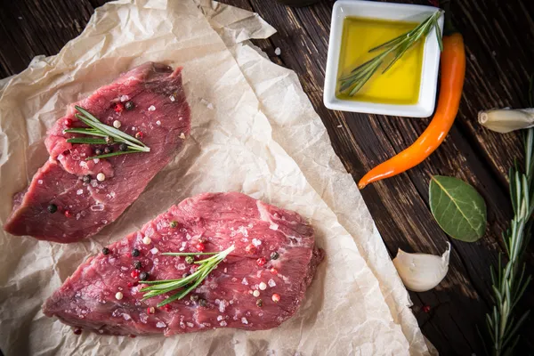 Bife cru na mesa de madeira — Fotografia de Stock