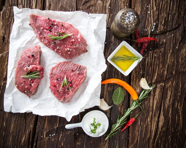 Raw beef steak on wooden table — Stock Photo, Image