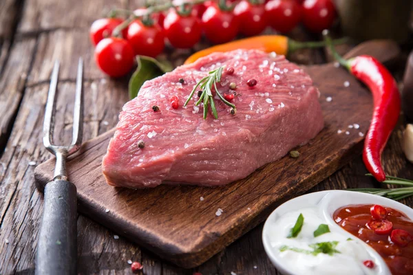 Bife cru na mesa de madeira — Fotografia de Stock