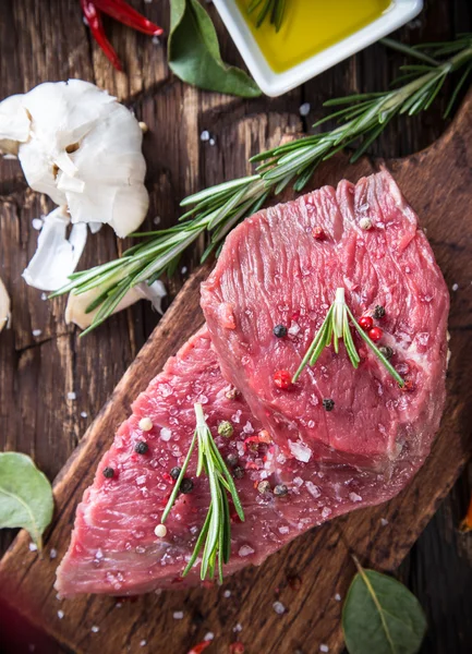 Raw beef steak on wooden table — Stock Photo, Image