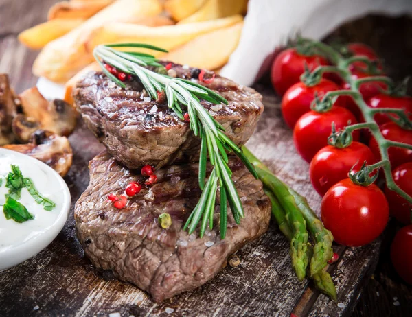 Bife de carne em mesa de madeira — Fotografia de Stock