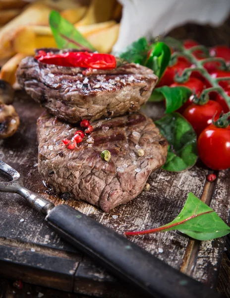 Beef steak on wooden table — Stock Photo, Image