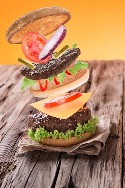 Smaczny hamburger na drewnianym stole — Zdjęcie stockowe
