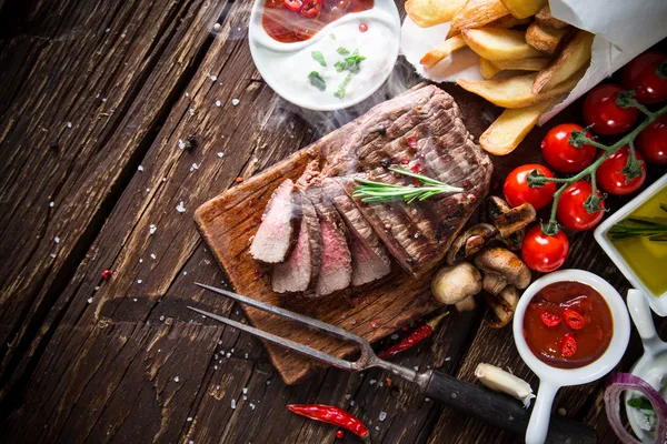 Stek smaczny wołowiny na drewnianym stole — Zdjęcie stockowe