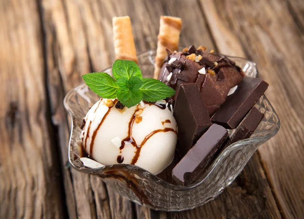 Kopečky zmrzliny na dřevěný stůl — Stock fotografie