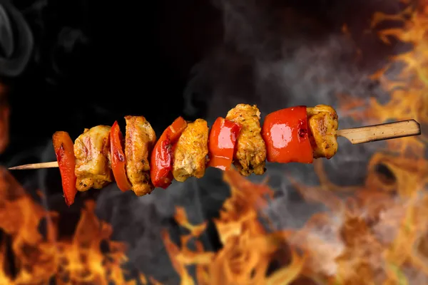 Tasty skewer on black background. Stock Photo