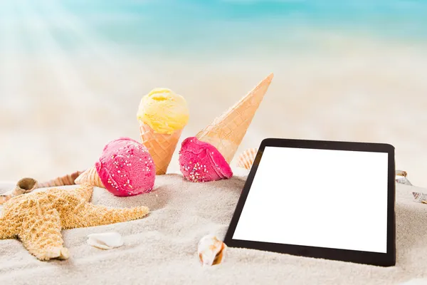 Es krim lezat dengan tablet di pantai — Stok Foto