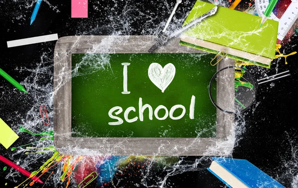 Wooden blackboard with school supplies — Stock Photo, Image