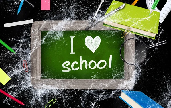 Wooden blackboard with school supplies — Stock Photo, Image