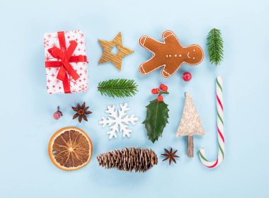Pastel arka planda çeşitli Noel süslemeleri. Yukarıdan aşağıya görünüm.