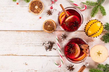 Noel baharatlı kırmızı şarap ve eski ahşap masada meyveler.