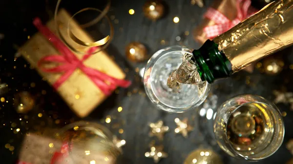 Champagne gieten in een glas uit een fles. — Stockfoto