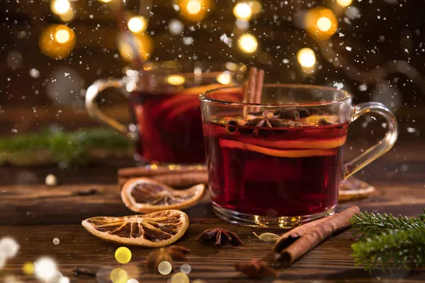 Vino tinto caliente de Navidad con especias y frutas en una mesa de madera vieja. — Foto de Stock