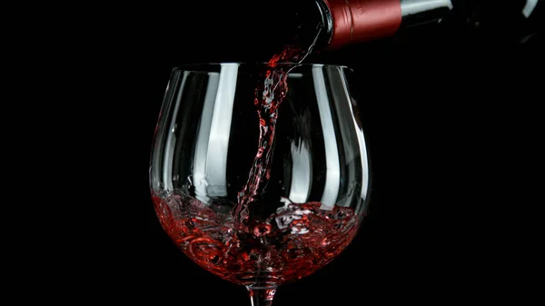 Pouring red wine, black background. — Stock Photo, Image