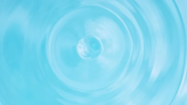 光の青の背景に孤立した水のスプラッシュ — ストック写真