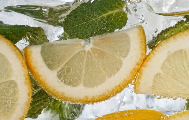 Taze meyve limonatasıyla köpüklü su ve buz küpleri.