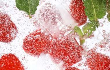 Taze meyve limonatasıyla köpüklü su ve buz küpleri.