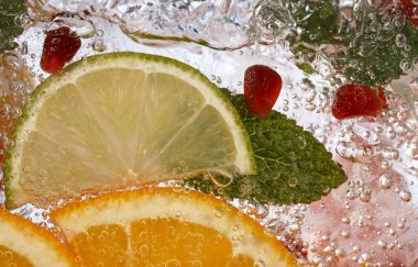 Taze meyve limonatasıyla köpüklü su ve buz küpleri.