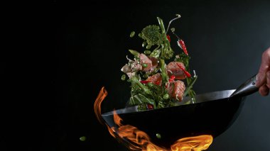 Wok Pan 'ın Dondurucu Hareketi ve Havadaki Uçan Malzemeler.
