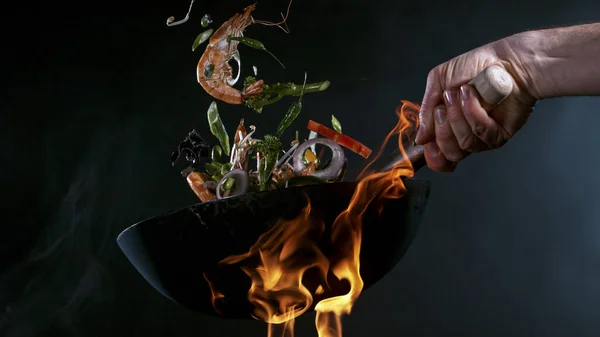 Freeze Motion of Wok Pan och flygande ingredienser i luften. — Stockfoto