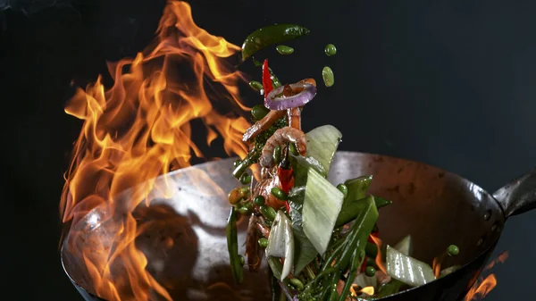 Freeze Motion of Wok Pan and Flying Ingredients in the Air. — Foto de Stock