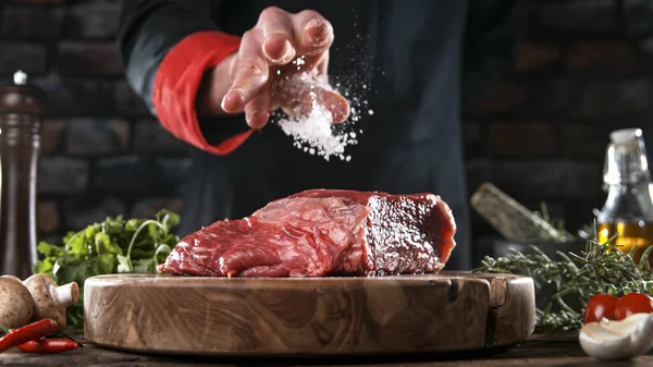 在美味的牛肉牛排上放盐和胡椒的特写 — 图库照片