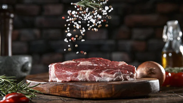 Крупный план падения соли и перца на вкусный говяжий стейк — стоковое фото