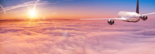 Passeggeri aereo commerciale che vola sopra le nuvole in luce del tramonto. — Foto Stock