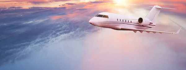 Avion jet privé volant au-dessus des nuages dans un magnifique coucher de soleil. — Photo