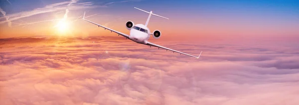 Avión jet privado volando por encima de las nubes en hermoso atardecer. — Foto de Stock