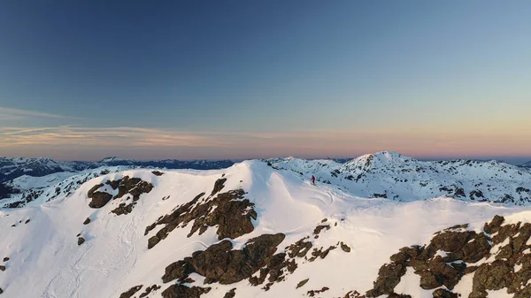 Tiro aéreo do pôr-do-sol da hora dourada com alpinista de esqui em movimento — Fotografia de Stock