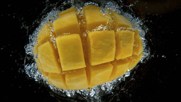 Verse mango valt in het water, bevries beweging. — Stockfoto