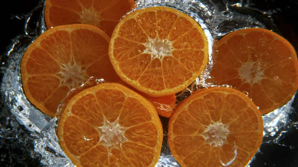 Mandarini freschi che cadono in acqua, moto di congelamento. — Foto Stock