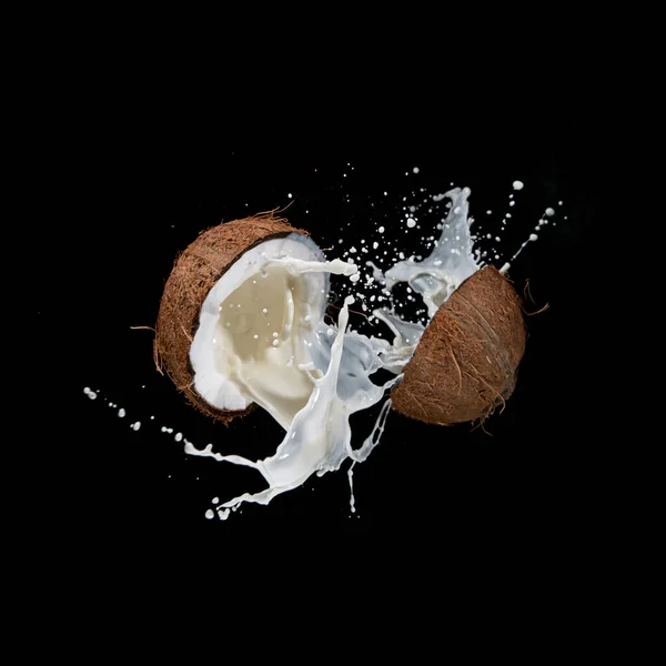 Coco agrietado con salpicadura de leche volando en el aire. — Foto de Stock