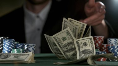 Poker oyuncusu Amerikan doları banknotları fırlatıyor