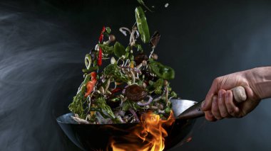 Wok Pan 'ın Dondurucu Hareketi ve Havadaki Uçan Malzemeler.