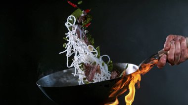 Wok Pan 'ın Dondurucu Hareketi ve Havadaki Uçan Malzemeler.