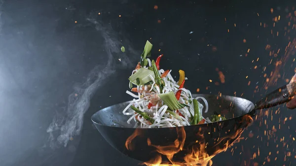 Freeze Motion of Wok Pan and Flying Ingredients in the Air. — Foto de Stock