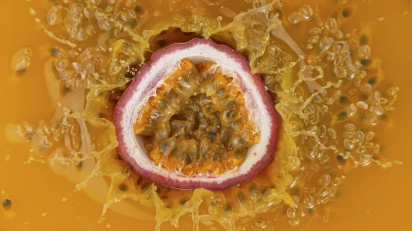 Fresca fruta de la pasión en rodajas cayendo en jugo —  Fotos de Stock