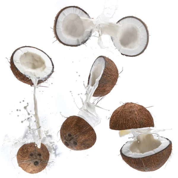 Gebarsten kokosnoot met melkplons in de lucht. — Stockfoto
