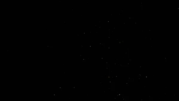Fliegende Staubpartikel auf schwarzem Hintergrund — Stockfoto