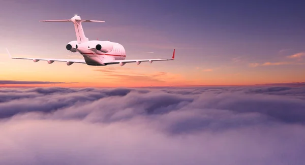 私人飞机喷气式客机在美丽的落日灯光下 在戏剧性的云彩之上飞行 旅行概念 — 图库照片