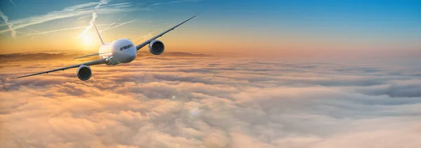 美しい日没の光の中で劇的な雲の上を飛んで商業飛行機のジェットライナー 旅行のコンセプト — ストック写真