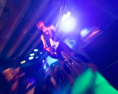 A man is playing electric guitar on stage, close-up.